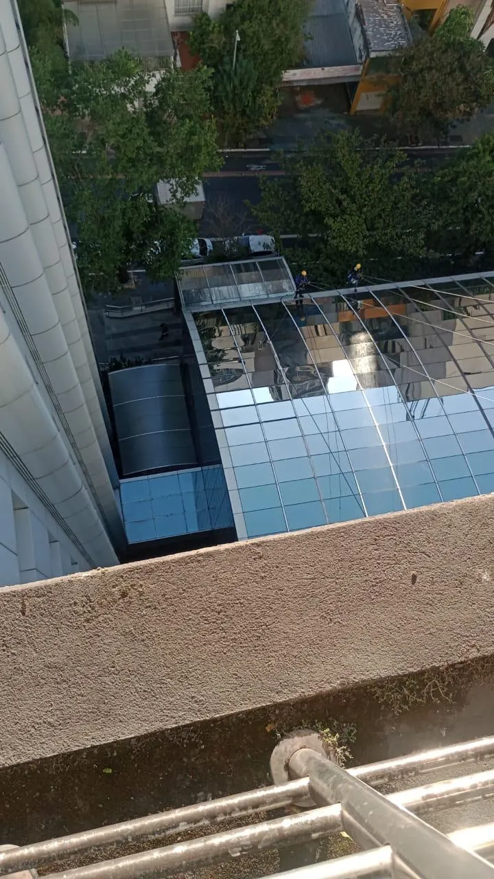Vista aérea de dois técnicos trabalhando sobre a cúpula de vidro do Hospital Paulistano
