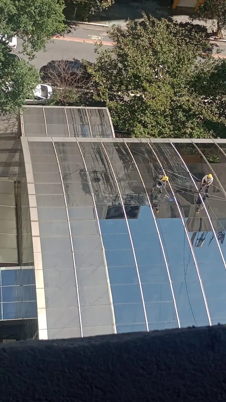 Técnicos em acesso por corda limpando a cúpula de vidro do Hospital Paulistano