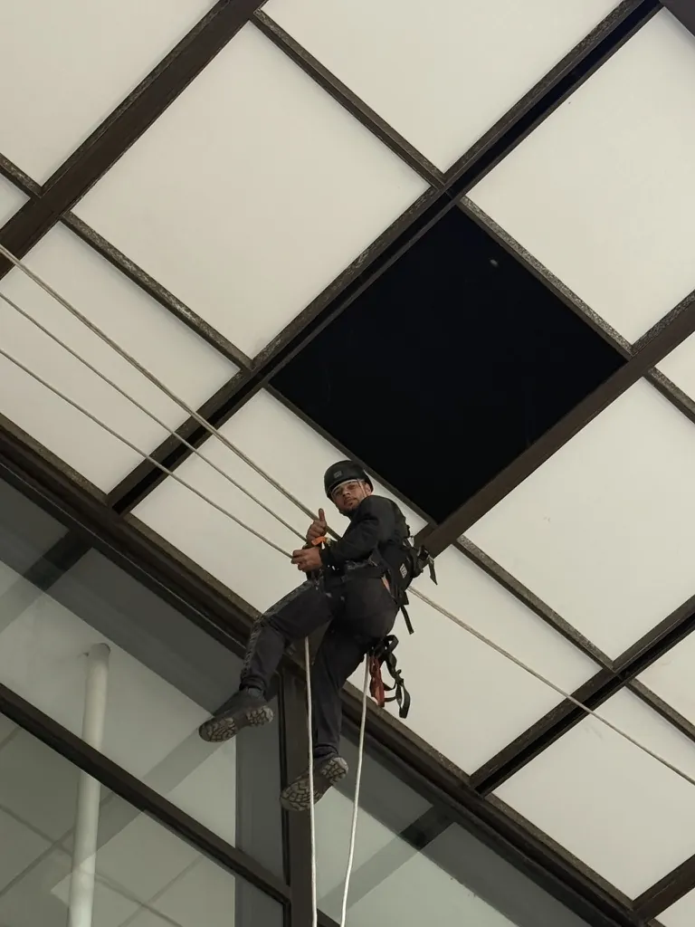 Técnico em acesso por corda sob a cobertura de vidro do Edifício Paulista 1000